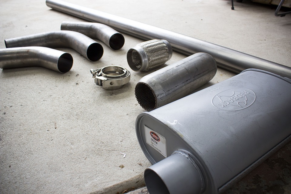 Automotive Exhaust System pieces set out side by side on the ground. prepped to fix common exhaust problems